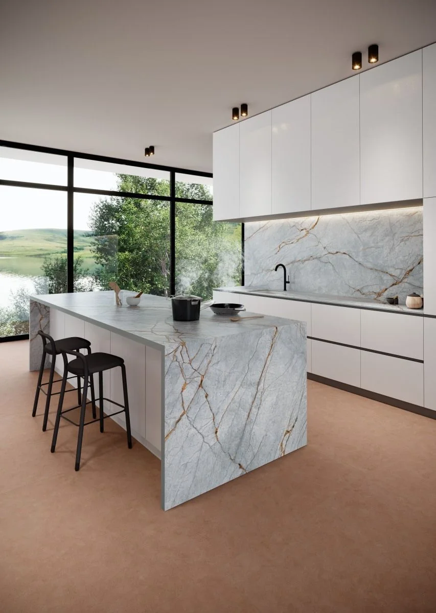 Blue Roma natural stone waterfall island and backsplash in a minimal white kitchen design