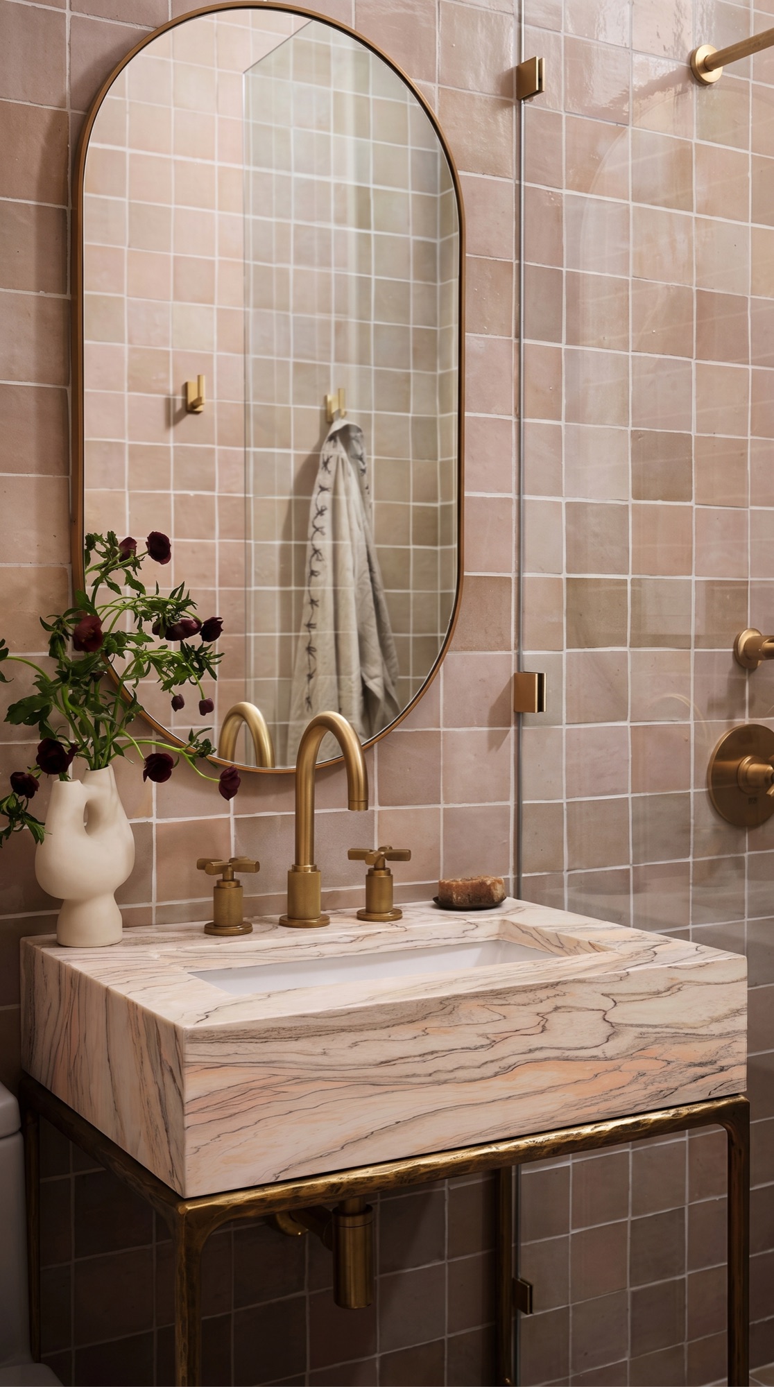 Calacatta Rosa integrated stone vanity against soft pink tile walls