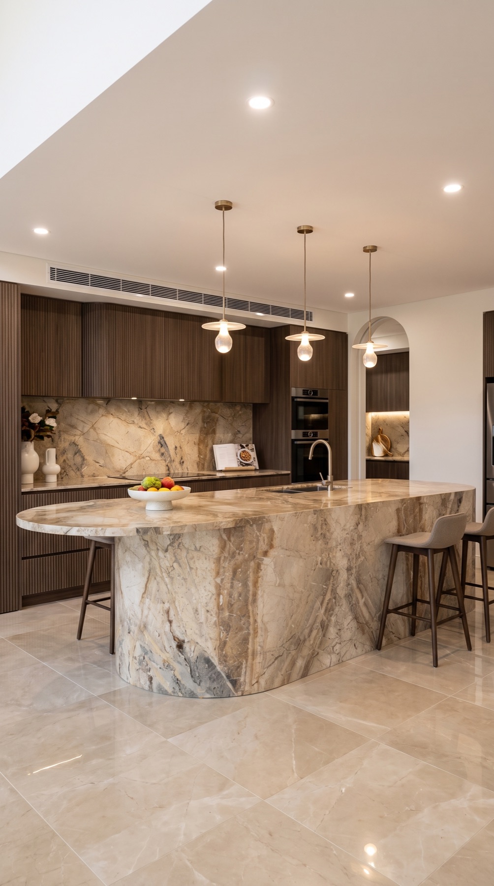 Contemporary kitchen with a large Breccia Pontificia marble island and matching backsplash against dark timber cabinetry