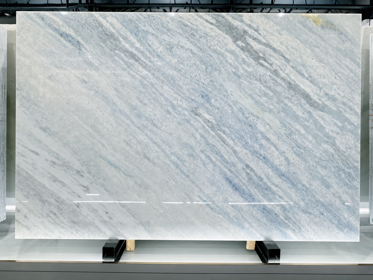 Full Iceberg Blue Quartzite slab with soft blue-grey diagonal movement in a stone showroom