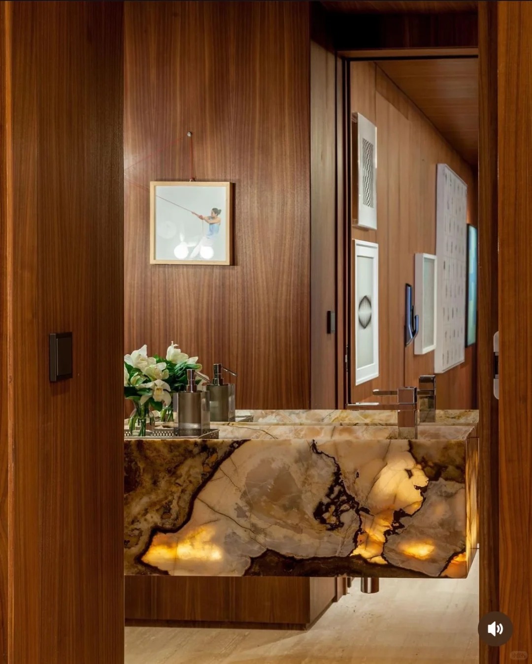 Backlit Patagonia stone floating vanity glowing in a walnut powder room