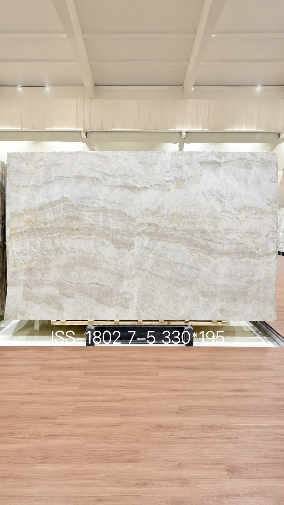 Large Taj Mahal quartzite slab on display with a pale cream background and soft layered movement