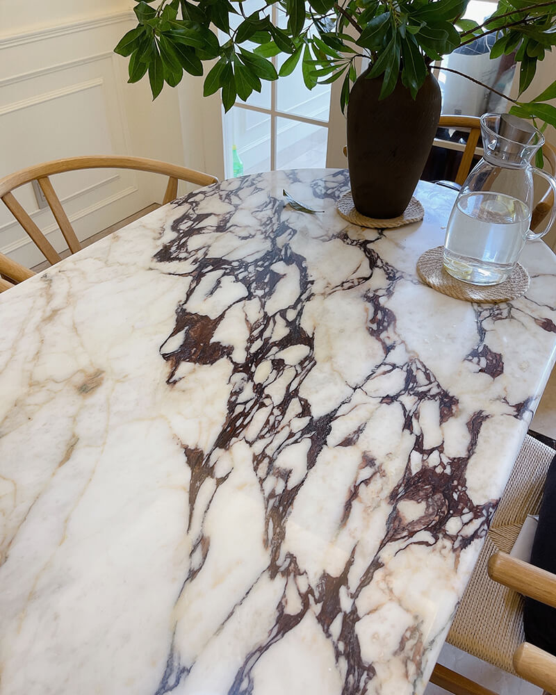 Close view of dramatic burgundy veining on a Calacatta Viola tabletop