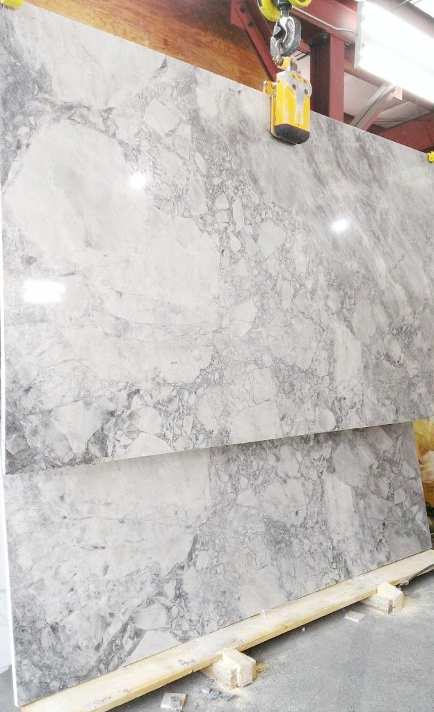 Two full Super White natural stone slabs showing pale grey brecciated movement