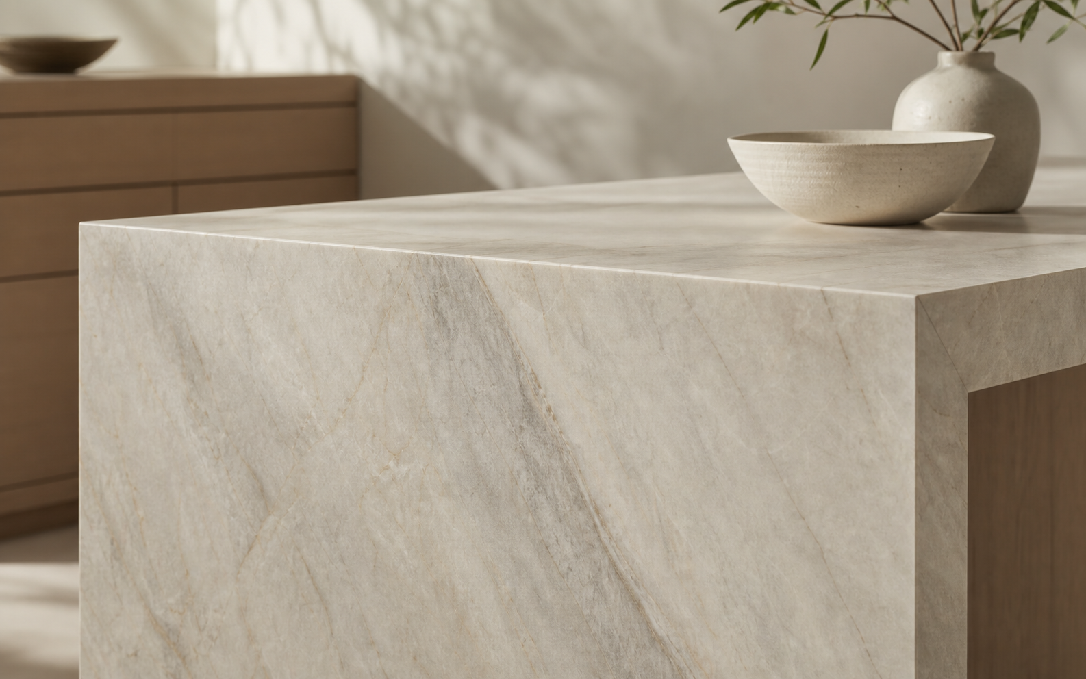 Close detail of a Taj Mahal quartzite waterfall edge with warm ivory and soft grey veining